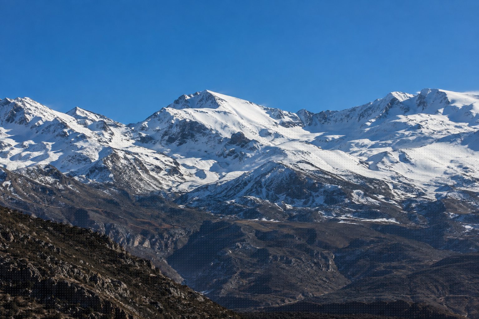 Cumbres nevadas de Sierra Nevada recortadas y nítidas en un día claro de invierno